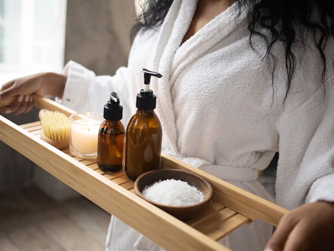 A person carrying essential oil bath salts, to enjoy a relaxing aromatherapy bath